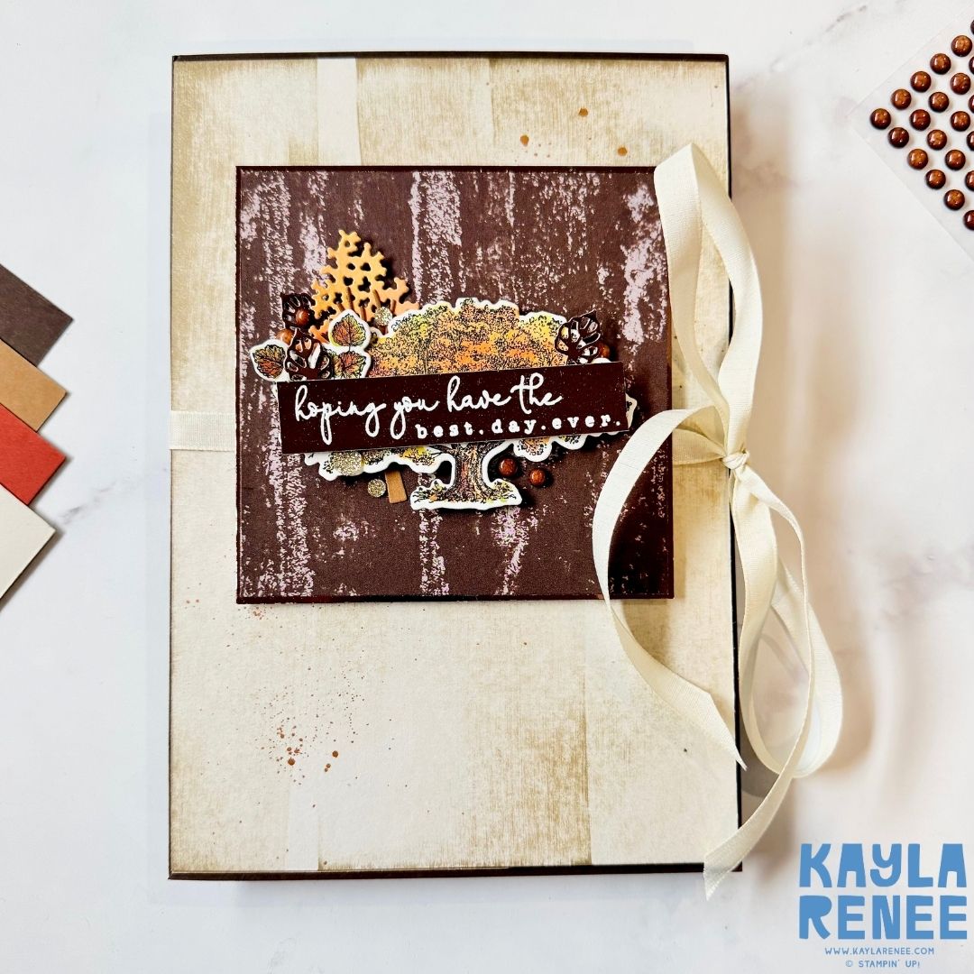 Handmade card with rustic cream and brown tones, tied with a soft ivory ribbon. The cover features a detailed stamped tree, autumn leaves, and acorns with a sentiment reading ‘Hoping you have the best day ever.