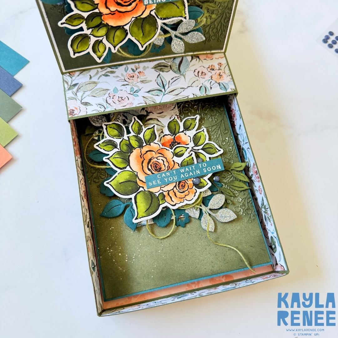 Pop-up drawer card opened to reveal a second hidden layer with another floral panel inside. The arrangement features orange and coral roses with green leaves and the sentiment ‘Can’t wait to see you again soon.’ The inner drawer and sides are lined with coordinating floral paper.