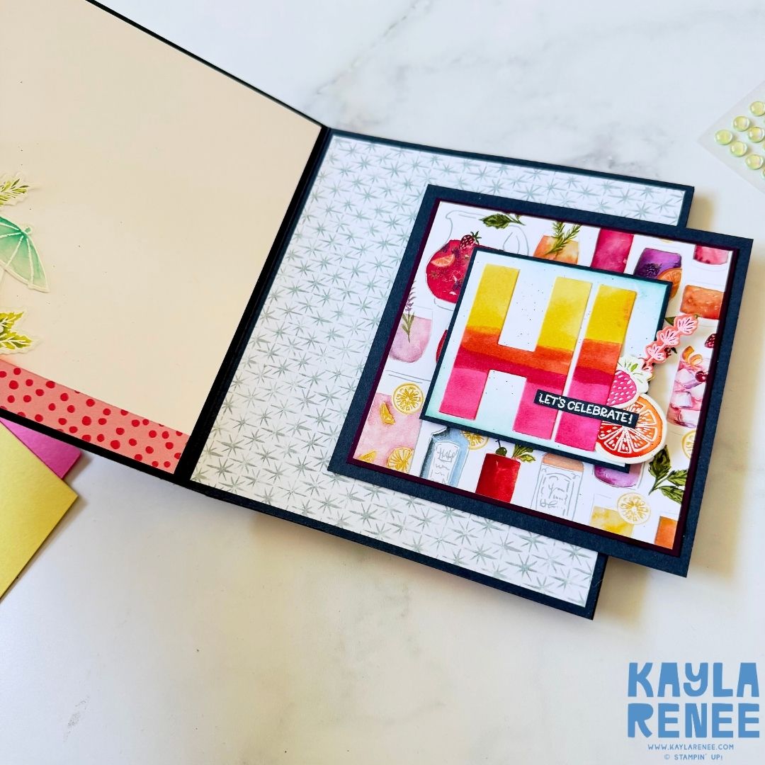 Close-up of the right panel of the interactive card featuring a large gradient ‘HI’ in pink, orange, and yellow tones with a small black sentiment label reading ‘Let’s Celebrate!’ surrounded by citrus slices and florals.