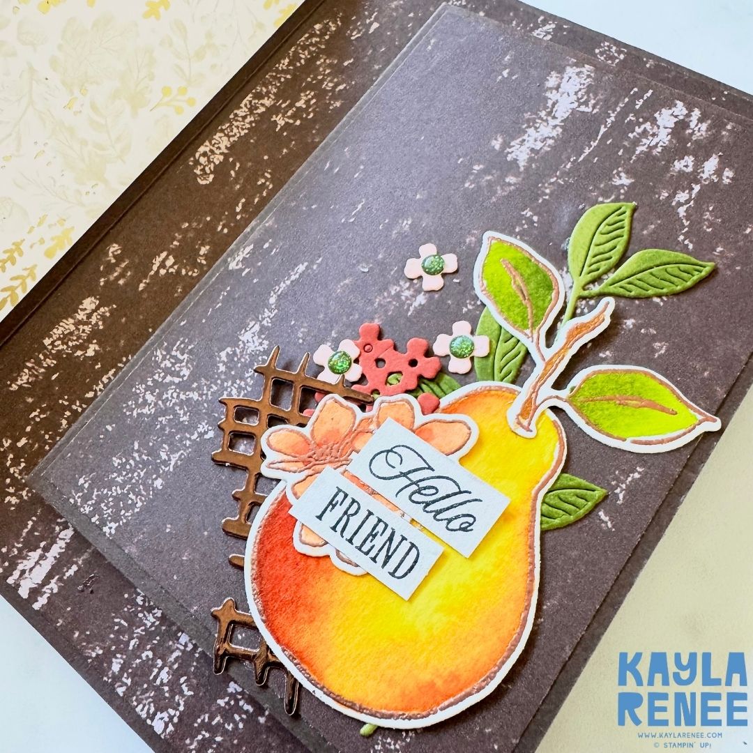 Inside of the card featuring a brown wood-textured panel decorated with a single watercolour pear, small die-cut flowers, and a grid embellishment. The sentiment reads ‘Hello Friend.