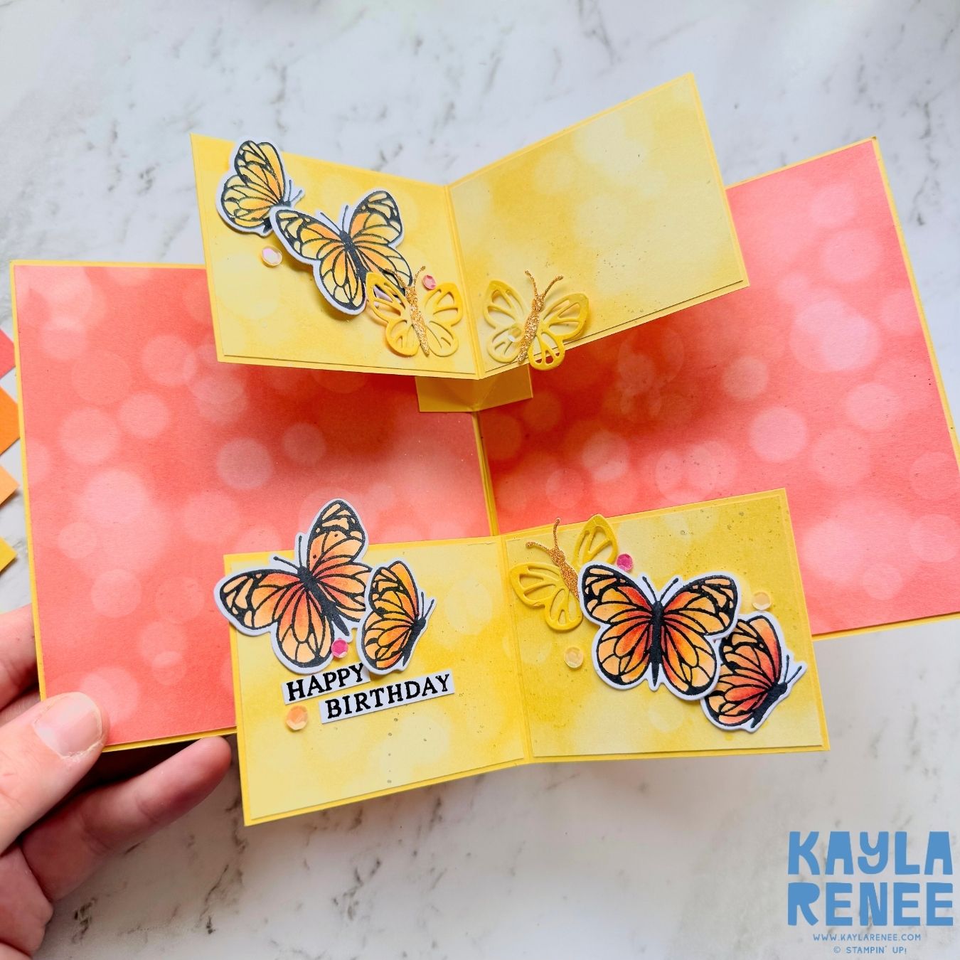 Inside of the fun fold card revealing bright yellow panels with multiple butterfly die-cuts and stamped images in orange and yellow. The greeting 'Happy Birthday' is displayed among the butterflies with added sequins for sparkle.