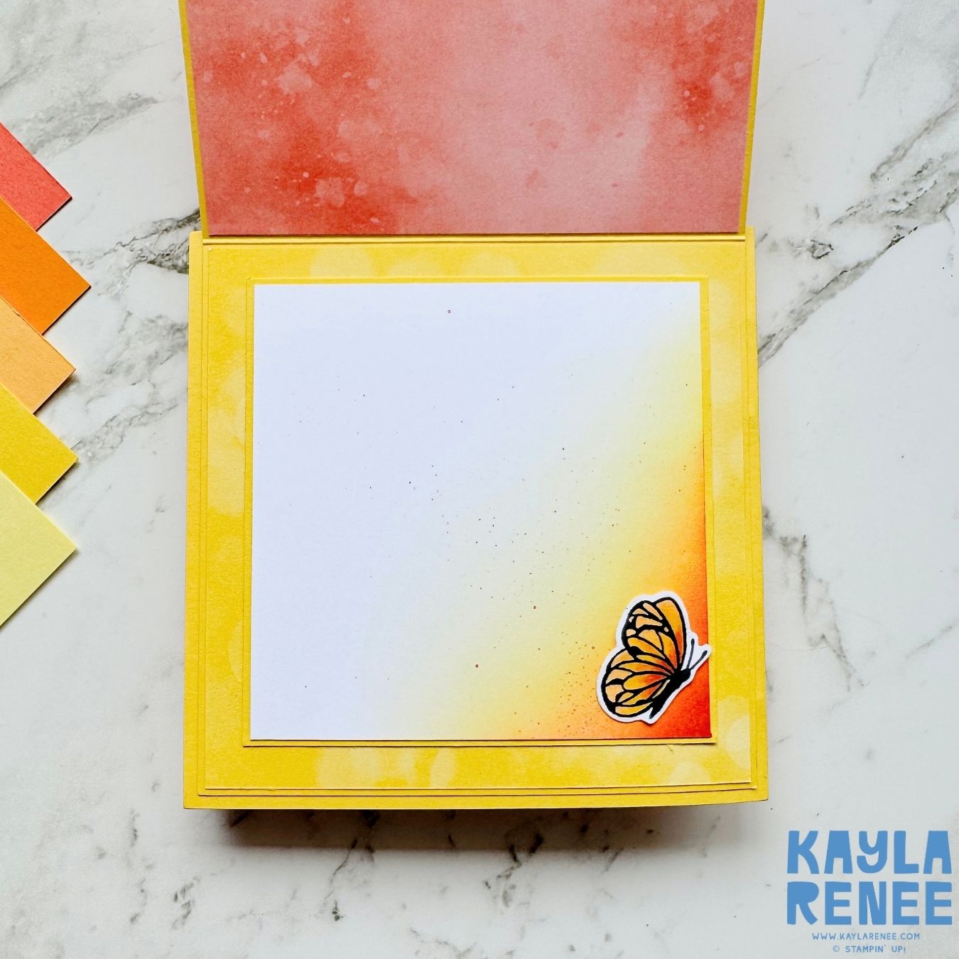 Interior writing space of the handmade card with a white panel softly blended with yellow and orange ink in the corner. A small butterfly embellishment decorates the bottom right corner.