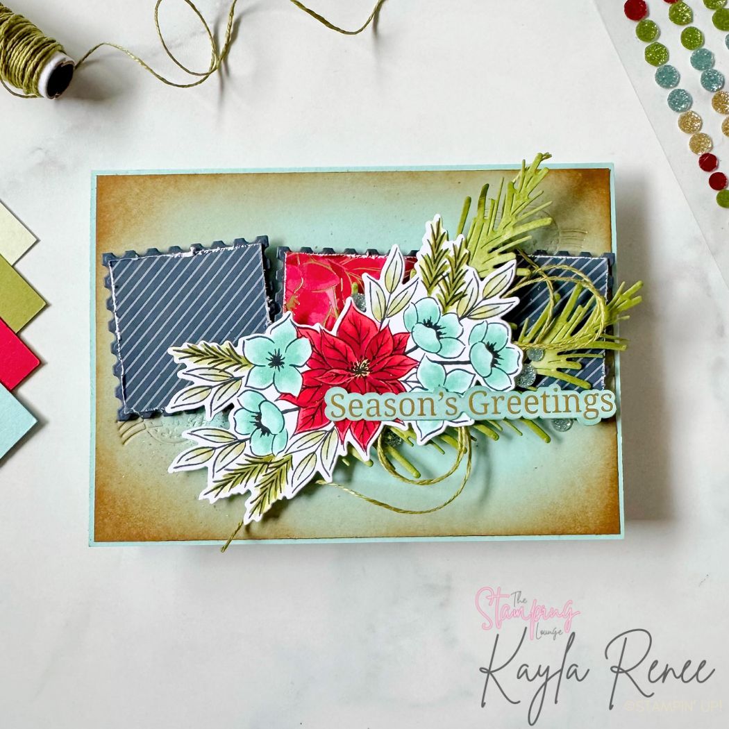 A handmade Christmas card with a soft aqua and warm brown ink-blended background, layered with three postage-stamp-style square panels. A detailed floral cluster featuring red poinsettias, aqua blue flowers, and greenery sits across the center, accented with gold twine loops and pine sprigs. The sentiment “Season’s Greetings” is placed across the floral arrangement. The card has a festive and elegant layered look.