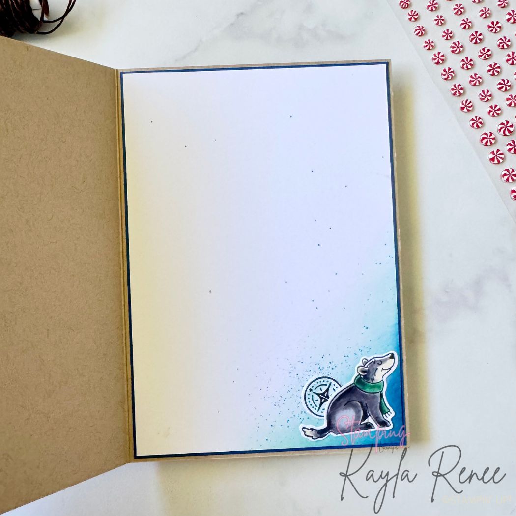 Inside of handmade card with clean white insert and blue ink blending in the corner. A small stamped puppy sits in the bottom right corner, howling joyfully with scattered ink splatters for detail.