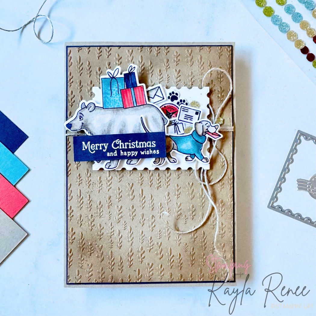 Christmas card featuring a polar bear and dachshund delivering presents, created using Stampin’ Up! products. Card front includes textured kraft background, scalloped postage-style die cut, coloured gifts, paw prints, envelopes and a “Merry Christmas and happy wishes” sentiment. Twine bow adds rustic touch. Perfect festive handmade card idea for animal lovers.