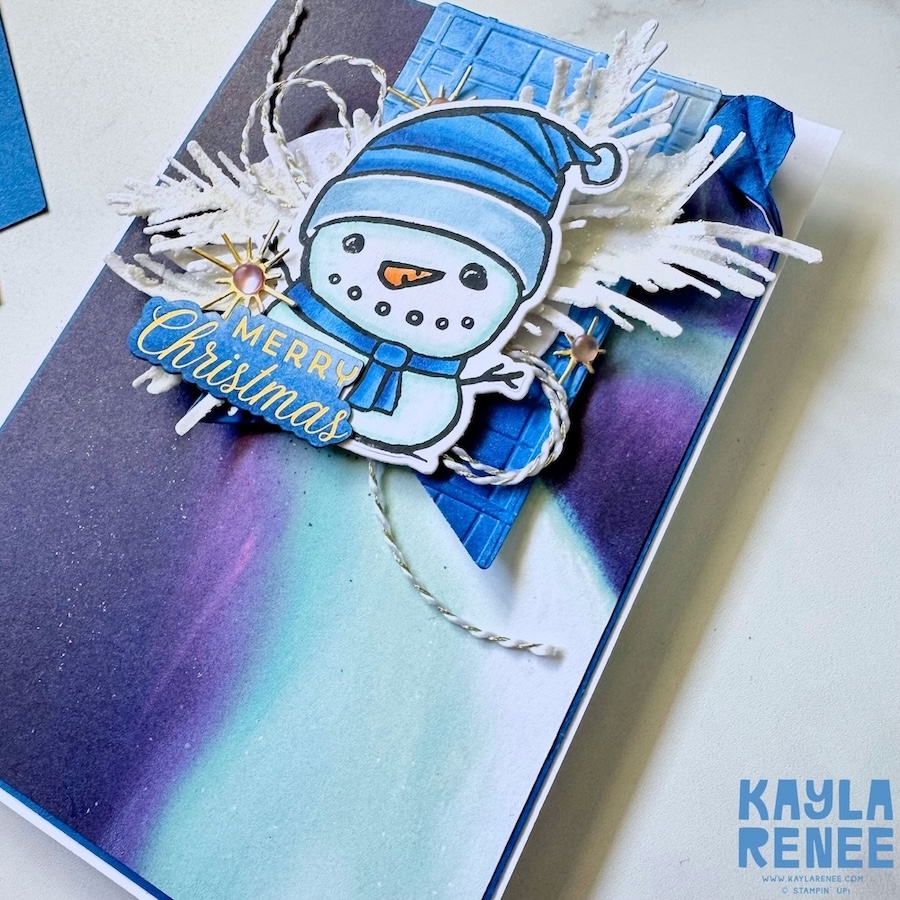 Detailed close-up of a snowman image from the Stampin’ Up! Festive Friends bundle, layered over embossed cardstock with white die-cut foliage and twine for a wintery Christmas card.