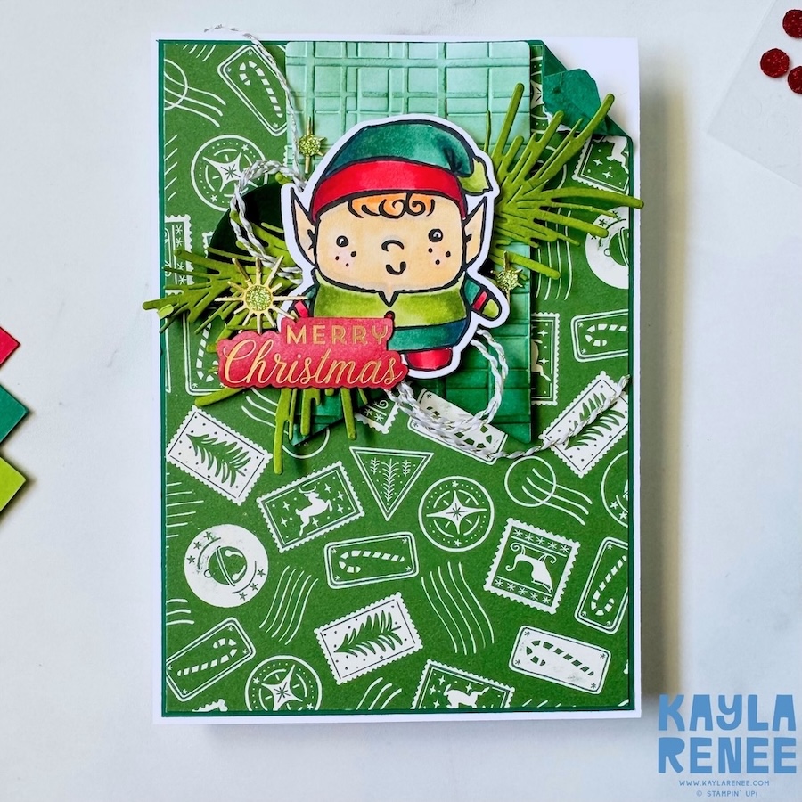 Elf-themed Christmas card made with the Stampin’ Up! Festive Friends bundle, featuring green patterned paper, embossed layers, pine foliage die cuts and a Merry Christmas sentiment.
