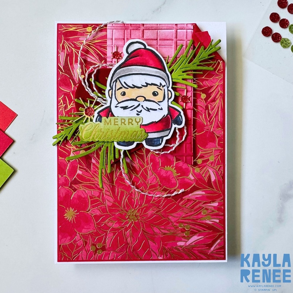 Santa Christmas card created using the Stampin’ Up! Festive Friends bundle, featuring red floral patterned paper, embossed layers, greenery die cuts and a Merry Christmas greeting.