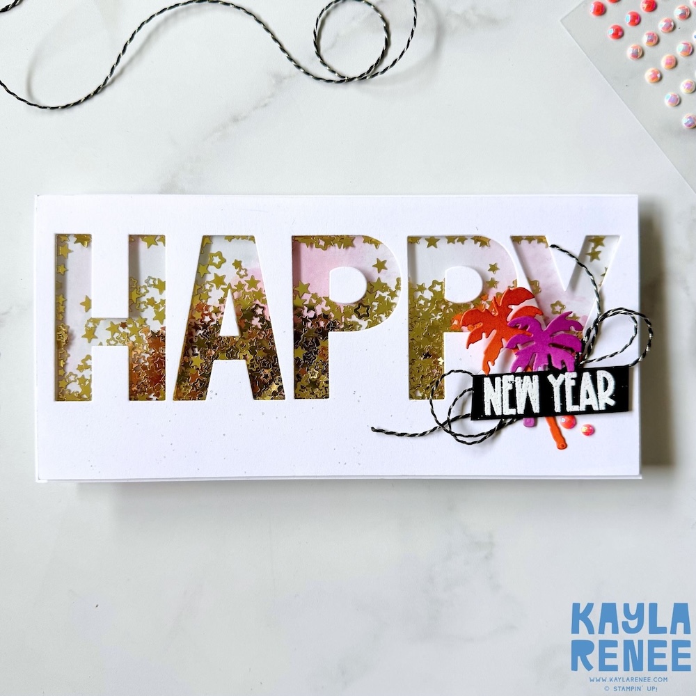 Handmade New Year shaker card with large die-cut “HAPPY” letters filled with gold star sequins, soft pink ink blending, black twine accents, and a “NEW YEAR” sentiment with bright palm tree die cuts on a white card base.