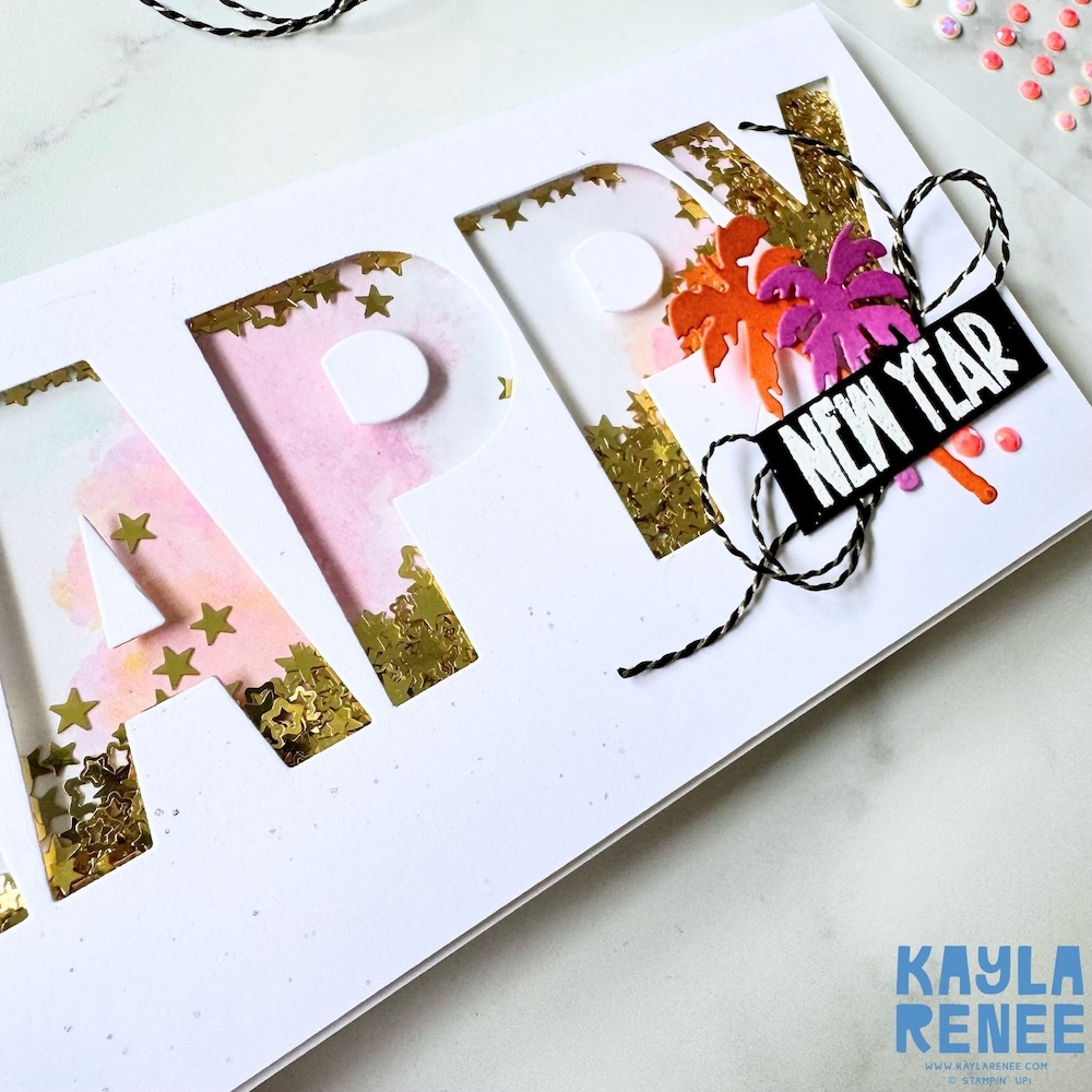 Detail view of the “HAPPY” shaker letters filled with gold star sequins, soft pink watercolour-style background, and raised white letter cut-outs on a handmade New Year card.