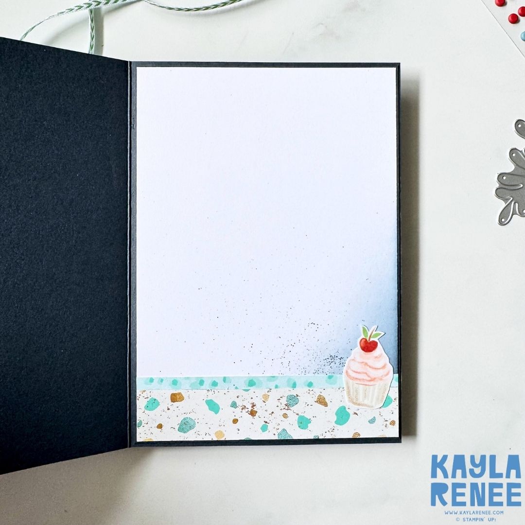 Inside view of a handmade card made with the Stampin’ Up! Hobby Haven Suite, featuring a clean white writing panel with subtle ink splatter and a small cupcake illustration in the bottom corner.
