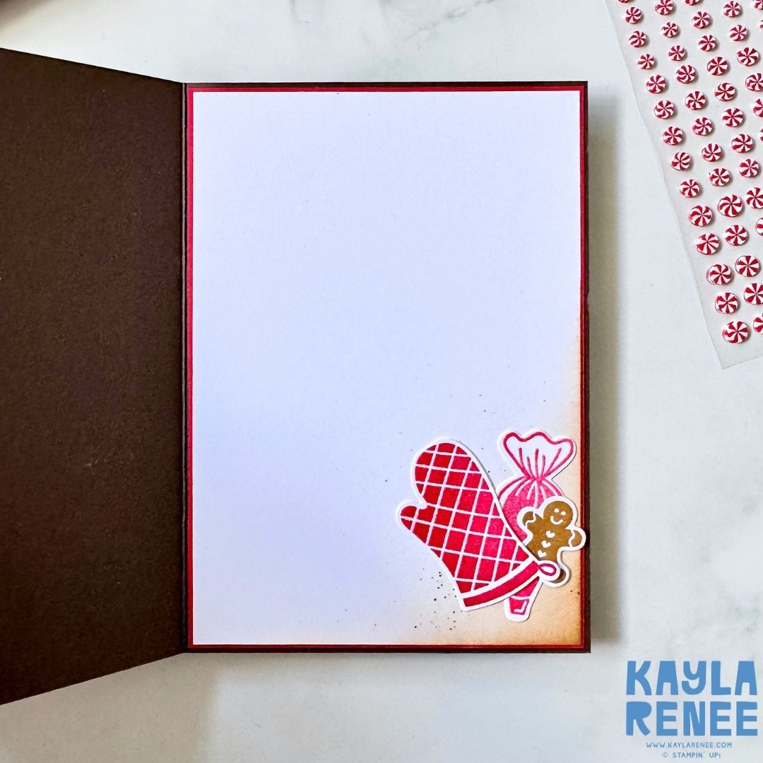 Inside view of a handmade Christmas card created with the Stampin’ Up! Homemade Treats bundle. Decorated with a red oven mitt, gingerbread cookie, and candy images in the lower corner, leaving space for a personal holiday message.