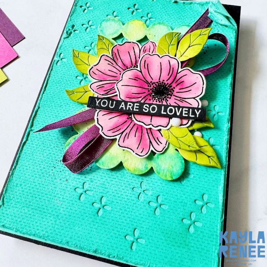 Close-up of teal floral card highlighting layered die cuts, ink blending, ribbon loop and subtle embossed pattern.