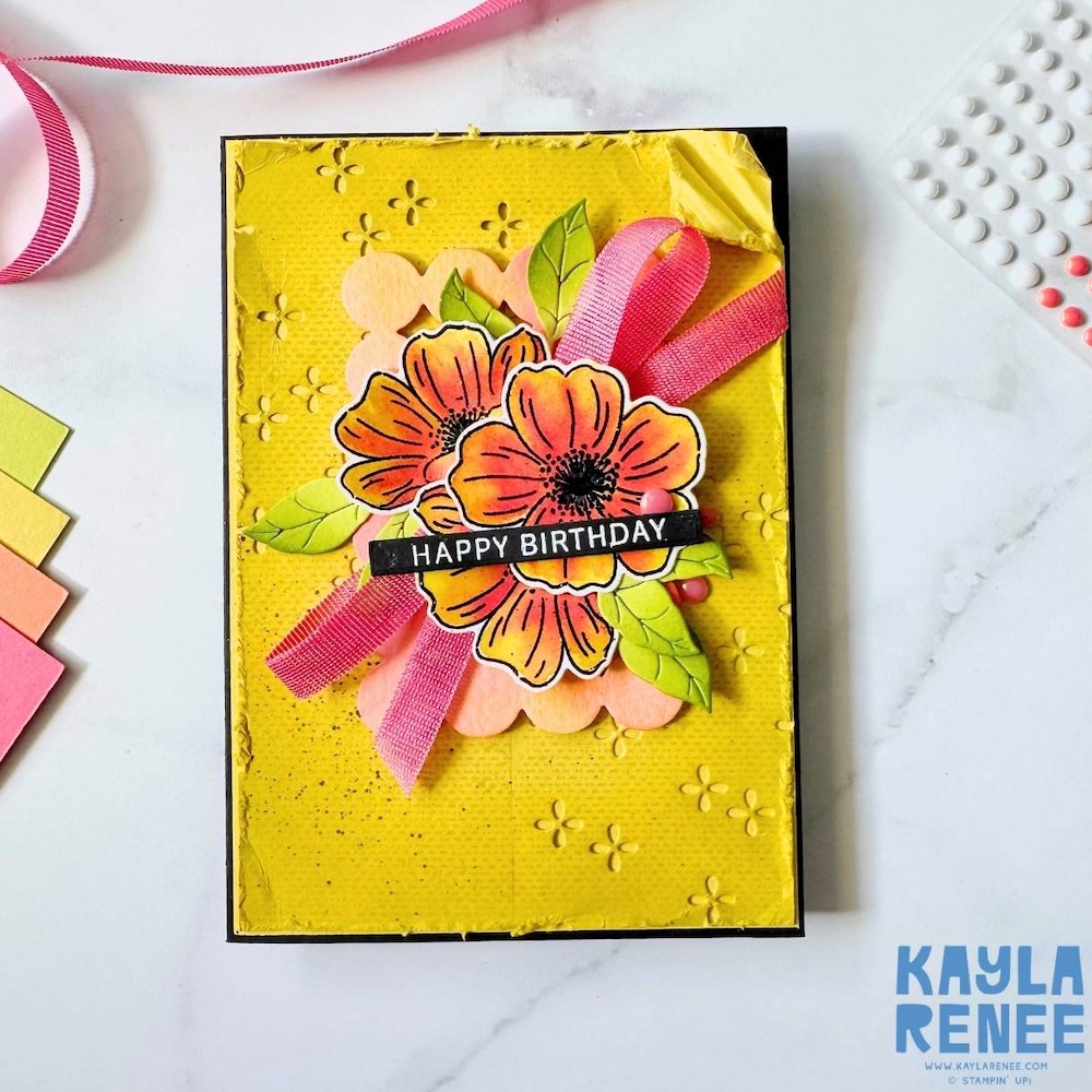 Bright yellow handmade birthday card with embossed texture, layered peach and orange flowers, green leaves and pink ribbon accent using Stampin’ Up! In Colors.