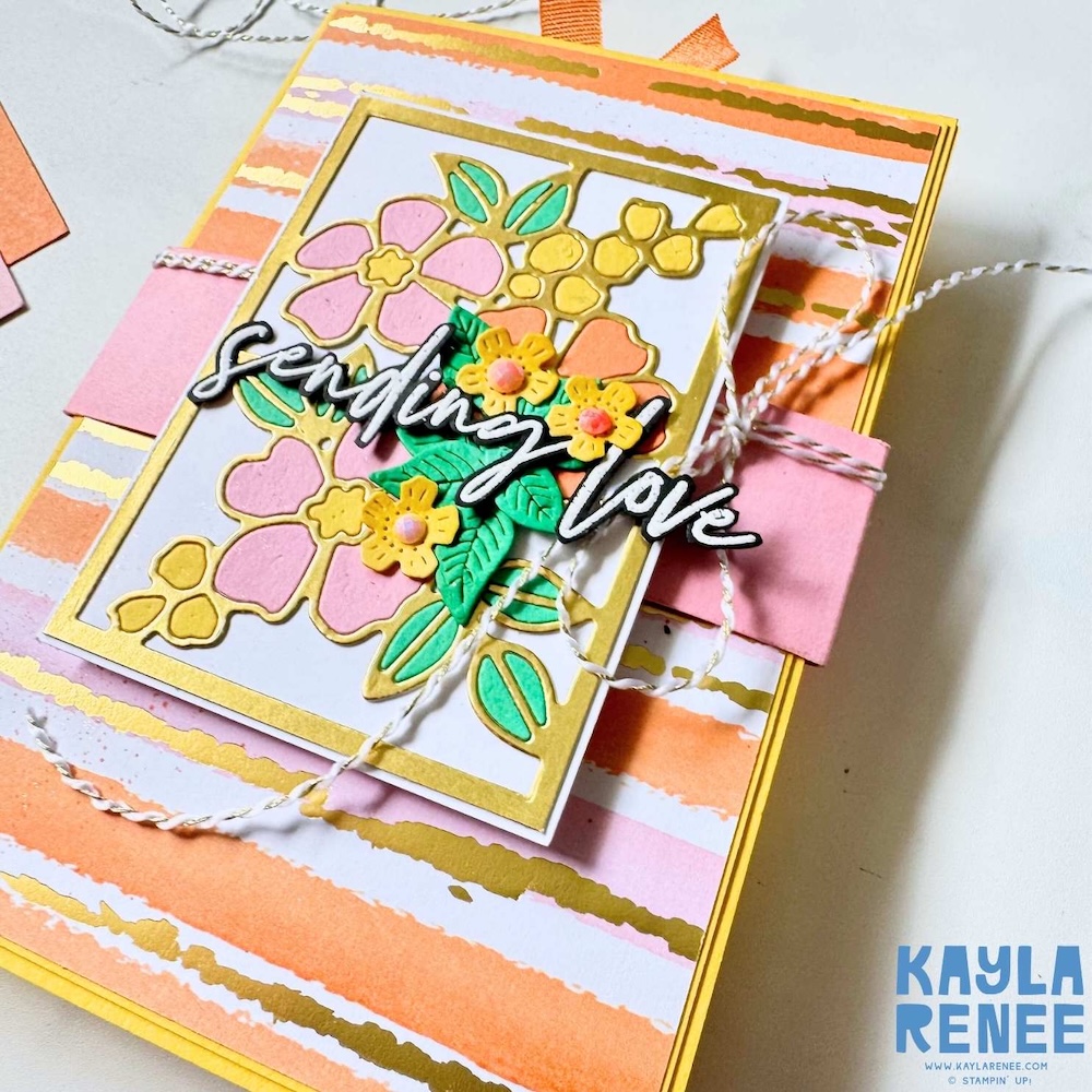 Angled detail shot showing layered Fragrant Layers floral dies, textured twine and dimensional elements on a pastel striped handmade card.
