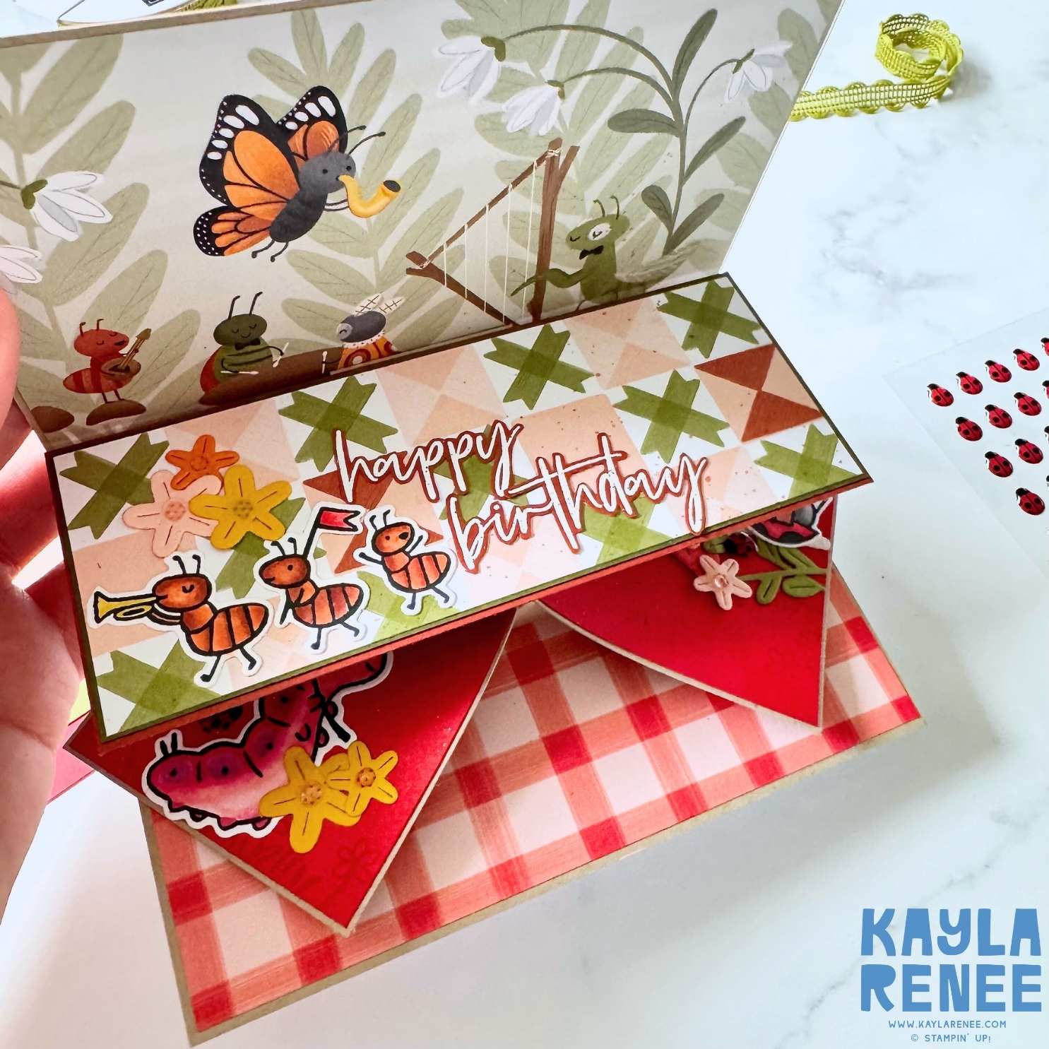 Interactive handmade birthday card opening to reveal accordion fold panels decorated with cute insects, patterned paper and a “happy birthday” sentiment.