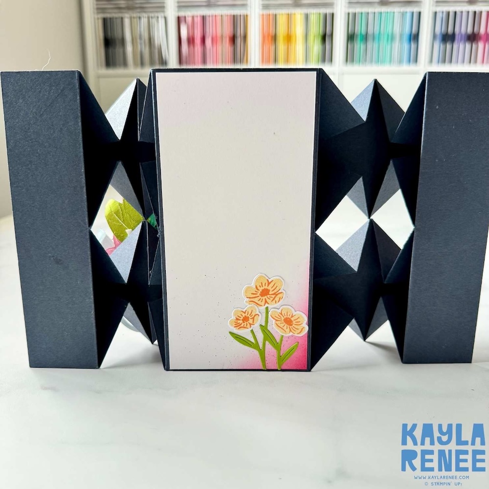 Back view of the floating diamond pop-up card showing accordion-style black diamond folds and a white writing panel with a small stamped floral accent.