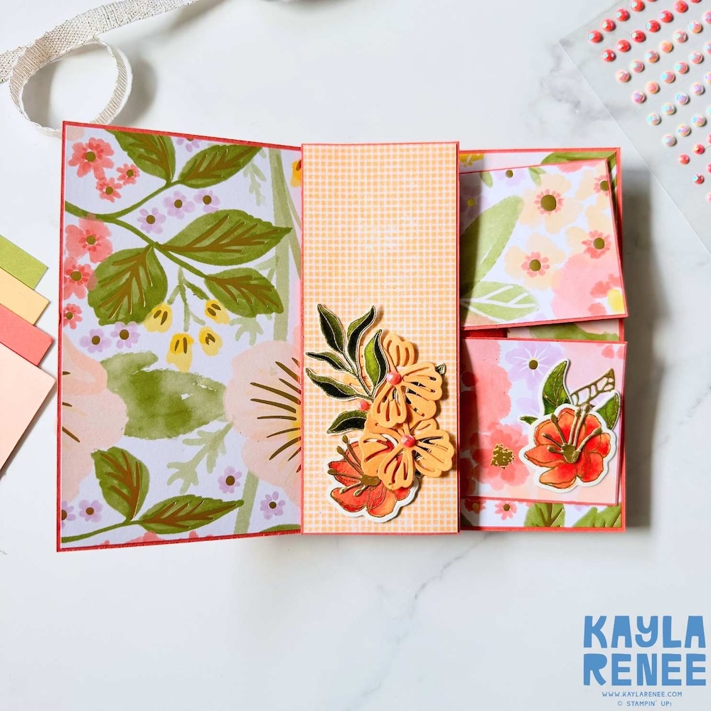 Top-down view of swing out mechanism revealing multiple folding panels decorated with orange floral die cuts and patterned paper.