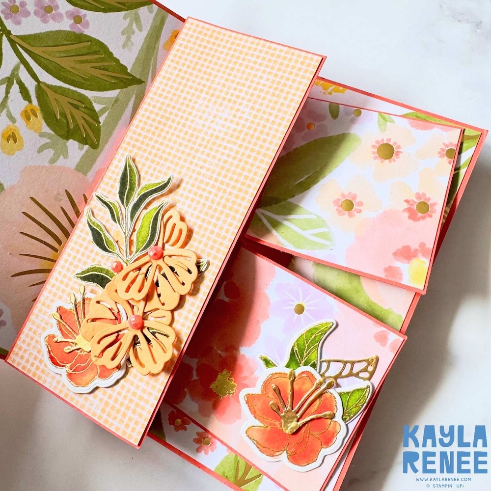 Close-up of inner swing panels featuring gingham pattern, floral die cuts and layered embellishments in peach and orange tones.