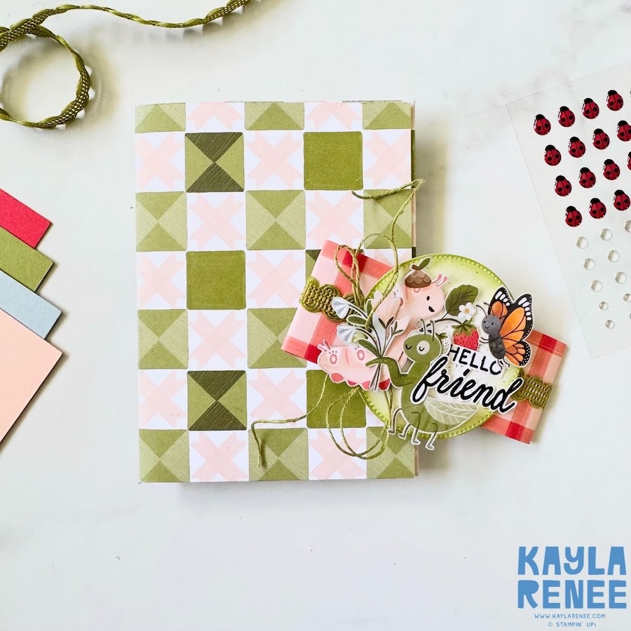 Handmade card opening to reveal mini album structure with fold-out panels and pockets, decorated with coordinating Cute as a Bug patterned paper and interactive layout.