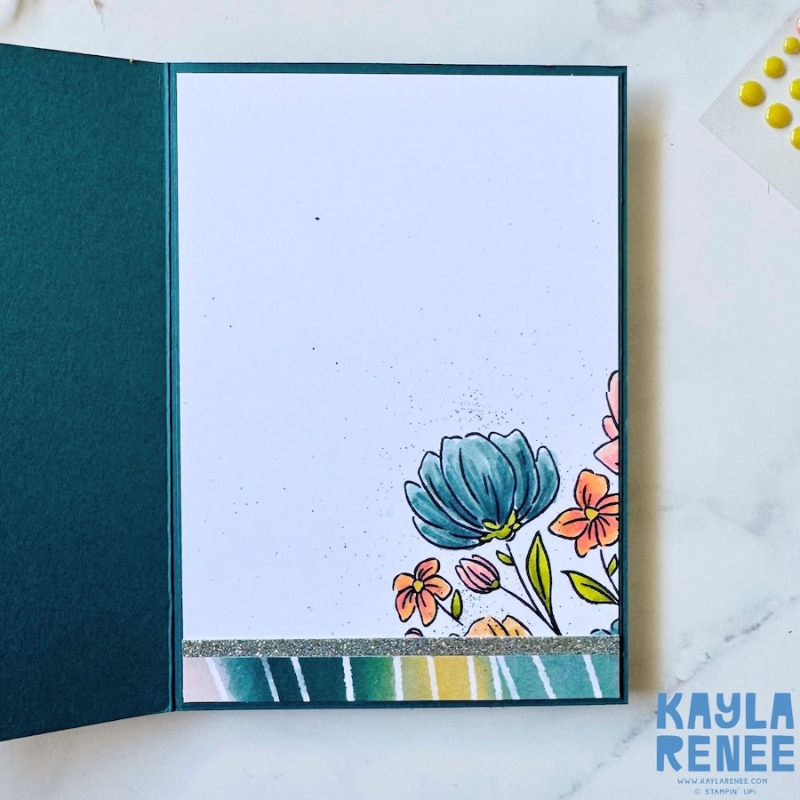 Inside view of the card featuring a clean white writing panel with coordinating stamped floral accents in the bottom corner and a strip of matching designer paper along the base.