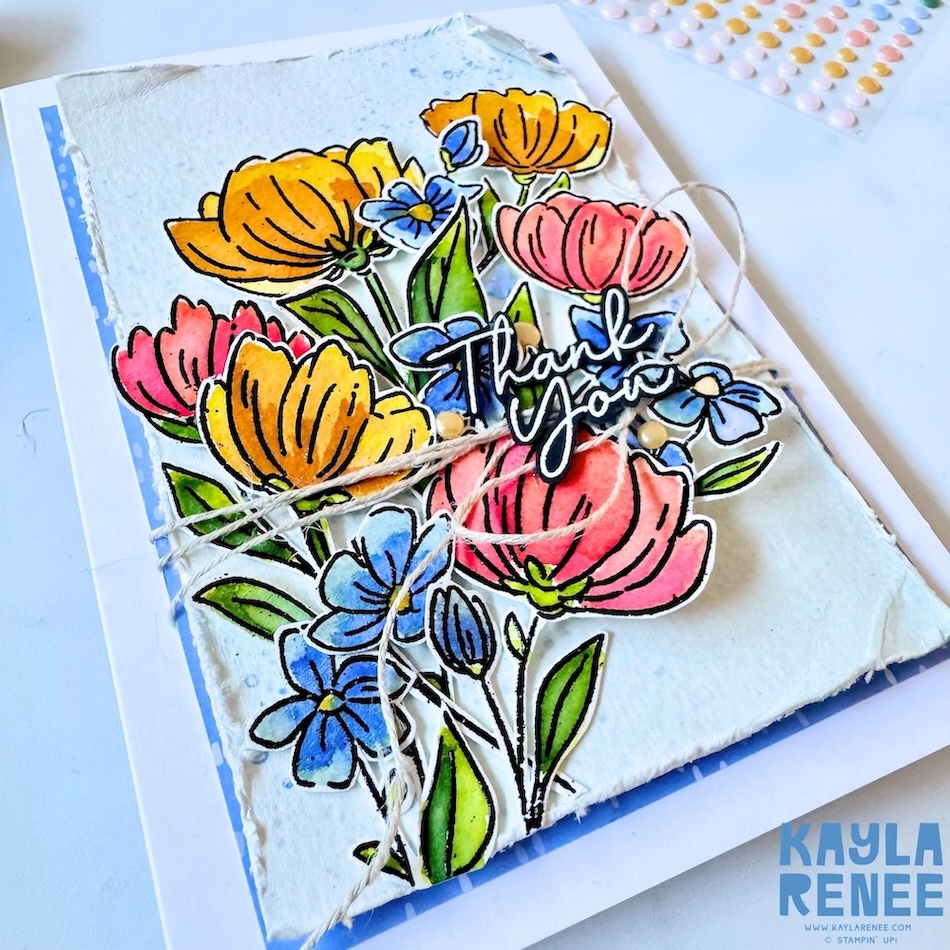 Close-up of watercoloured floral arrangement using Flowers Fair and Scalloped Blooms stamps, showcasing vibrant pink, yellow, and blue flowers with layered dimension and twine wrap.
