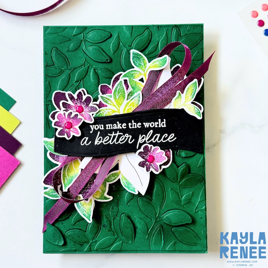 Handmade Stampin’ Up! Garden Poetry Suite card with a textured dark green embossed background, layered floral die cuts in pink and green tones, and a flowing purple ribbon behind a black sentiment banner.