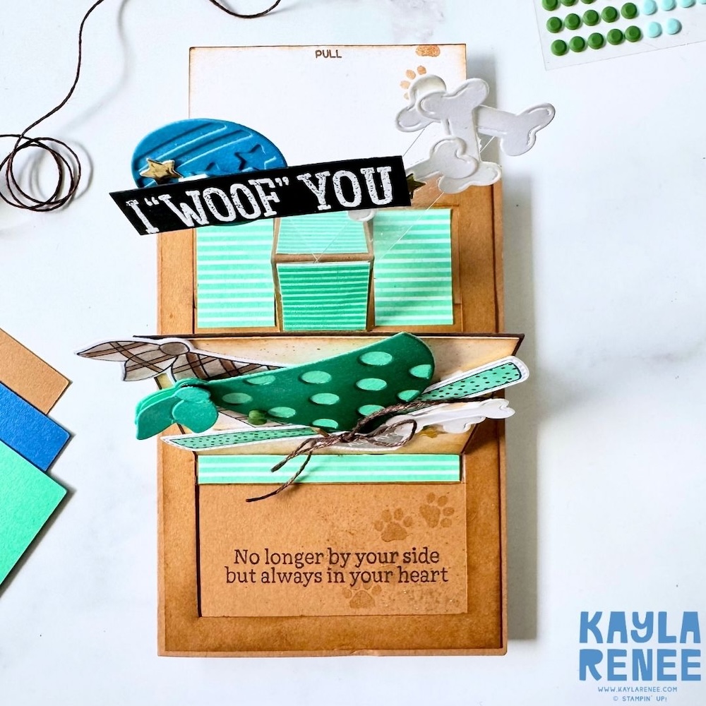 Interactive slider mechanism partially pulled out, revealing hidden panels and the sentiment “No longer by your side but always in your heart” with paw print accents.