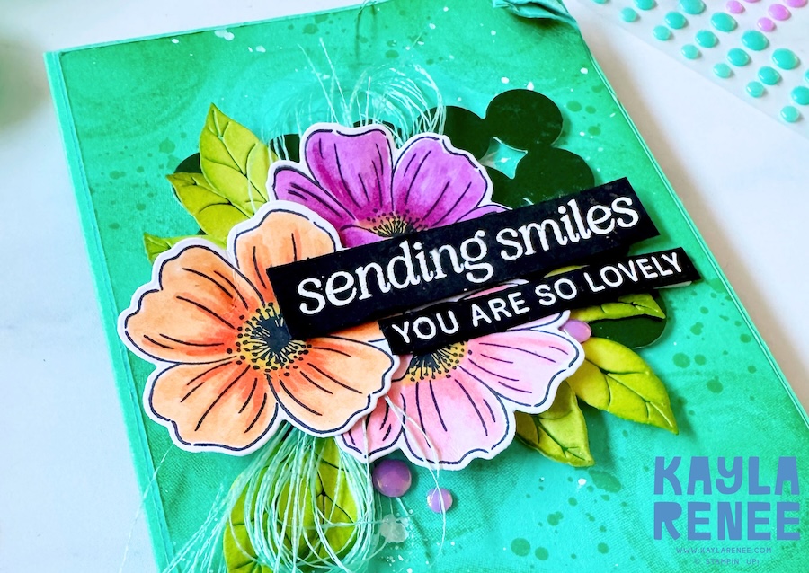 Close-up of handmade floral card using Stampin’ Up! Lovely Arrangements bundle, featuring layered flowers in 2024–2026 In Colours with “sending smiles” sentiment on a textured green background.