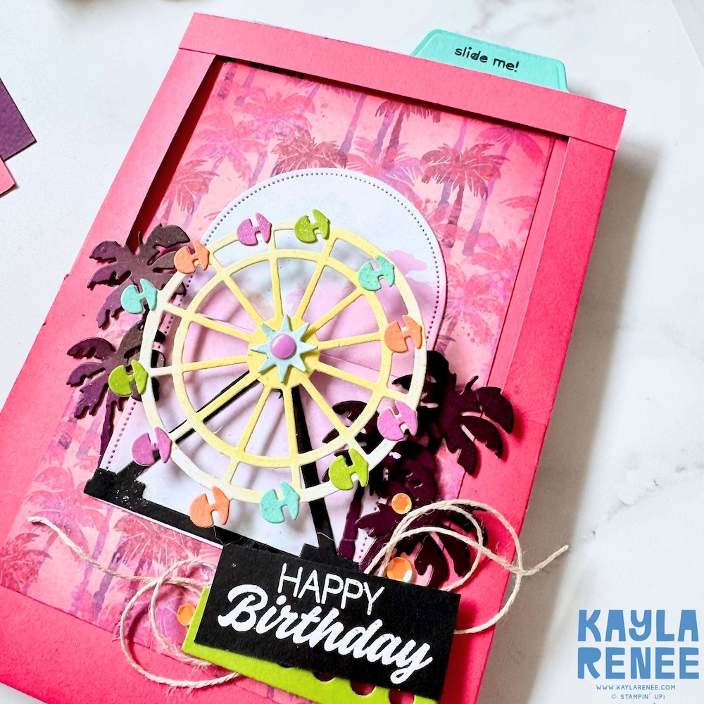 Close-up of a Stampin’ Up! Beach Boardwalk suite card showcasing a layered Ferris wheel die cut, tropical palm silhouettes, twine accents, and a bold “Happy Birthday” sentiment on a vibrant pink frame.