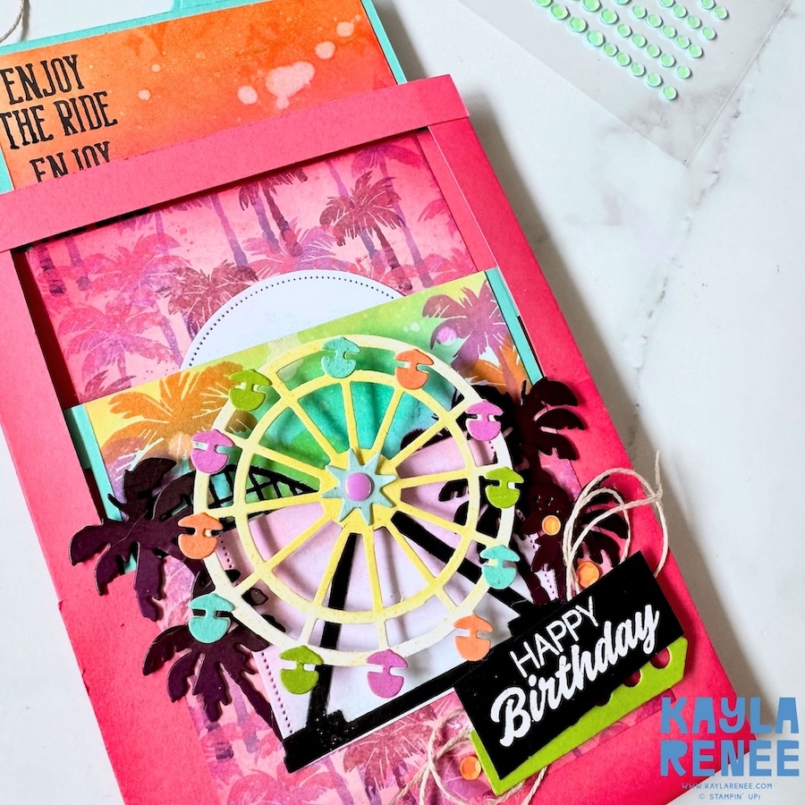 Angled close-up of a Stampin’ Up! Beach Boardwalk suite fun fold card highlighting dimensional layers, colourful Ferris wheel gondolas, palm tree die cuts, and textured twine embellishments.