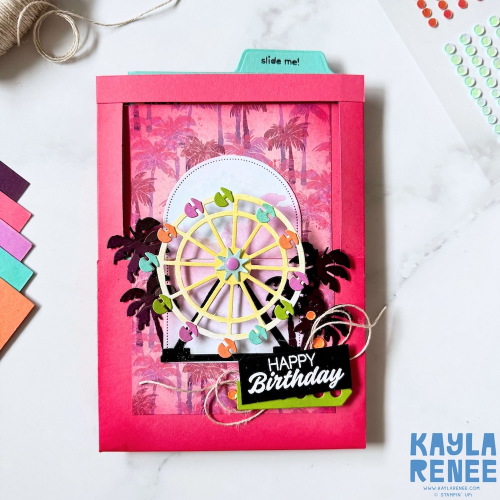 Front view of a handmade Stampin’ Up! Beach Boardwalk suite card featuring a Ferris wheel focal point, layered tropical elements, sequins, and a “Happy Birthday” sentiment on a bright pink background.