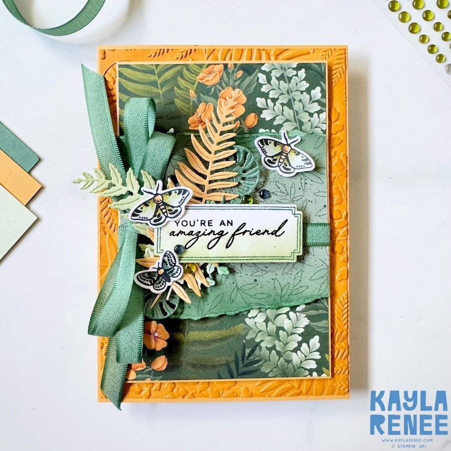 Handmade floral friendship card inspired by Global Design Project #GDP548, created with the Stampin’ Up! Moonlit Flora Suite and the new Stampin’ Up! colours Golden Glow and Peaceful Pine, featuring leafy patterned paper, layered foliage, moth embellishments, textured ribbon, and embossed details.