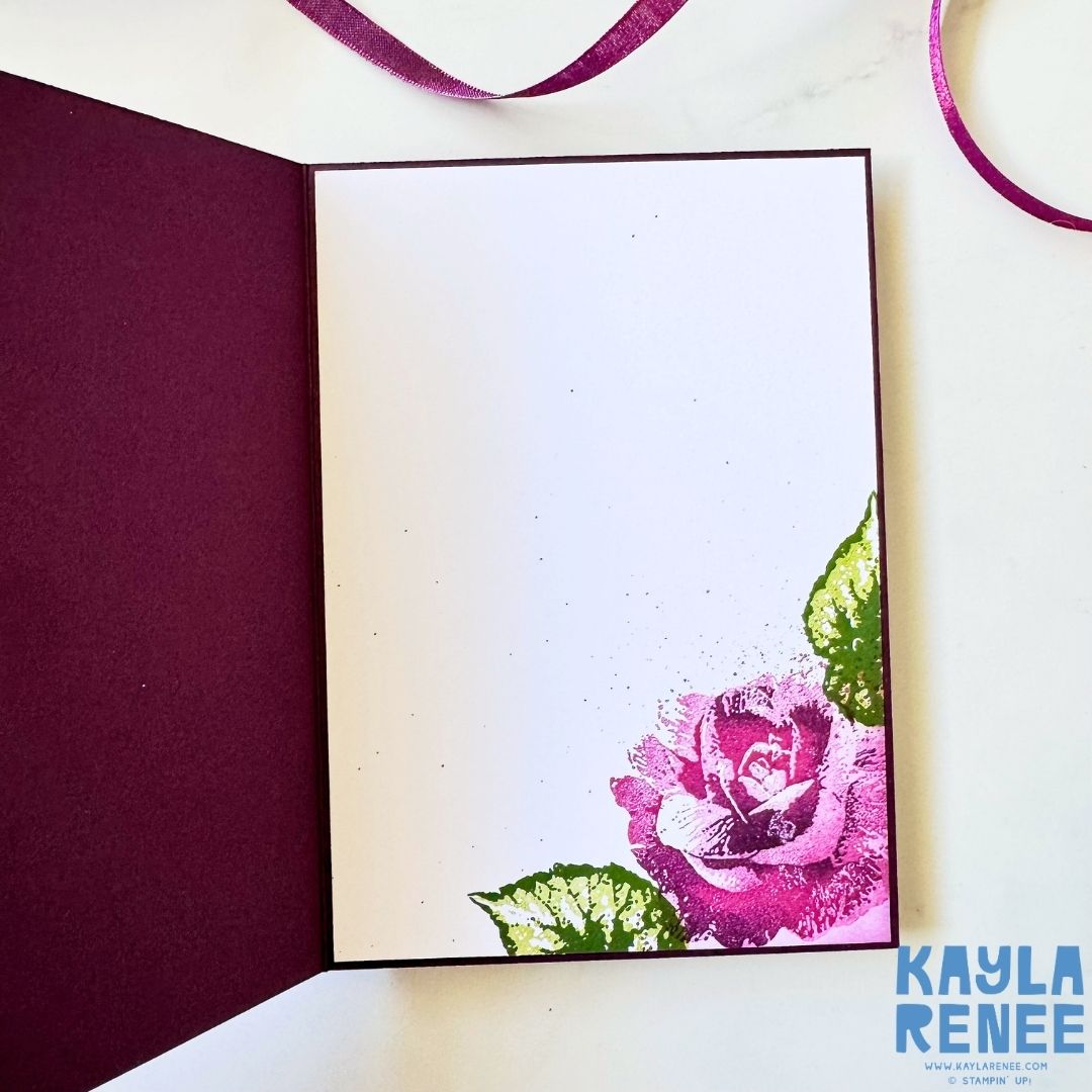 Inside of a handmade Stampin’ Up! Begonia Belle card with a white writing panel bordered in deep purple and a stamped pink and purple rose with green leaves decorating the lower right corner.