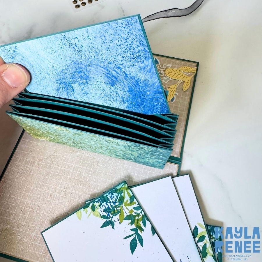 Pop-up expanding pocket card with six individual pull-out cards displayed beside the accordion pocket, each providing space for handwritten messages and featuring coordinating botanical designs.