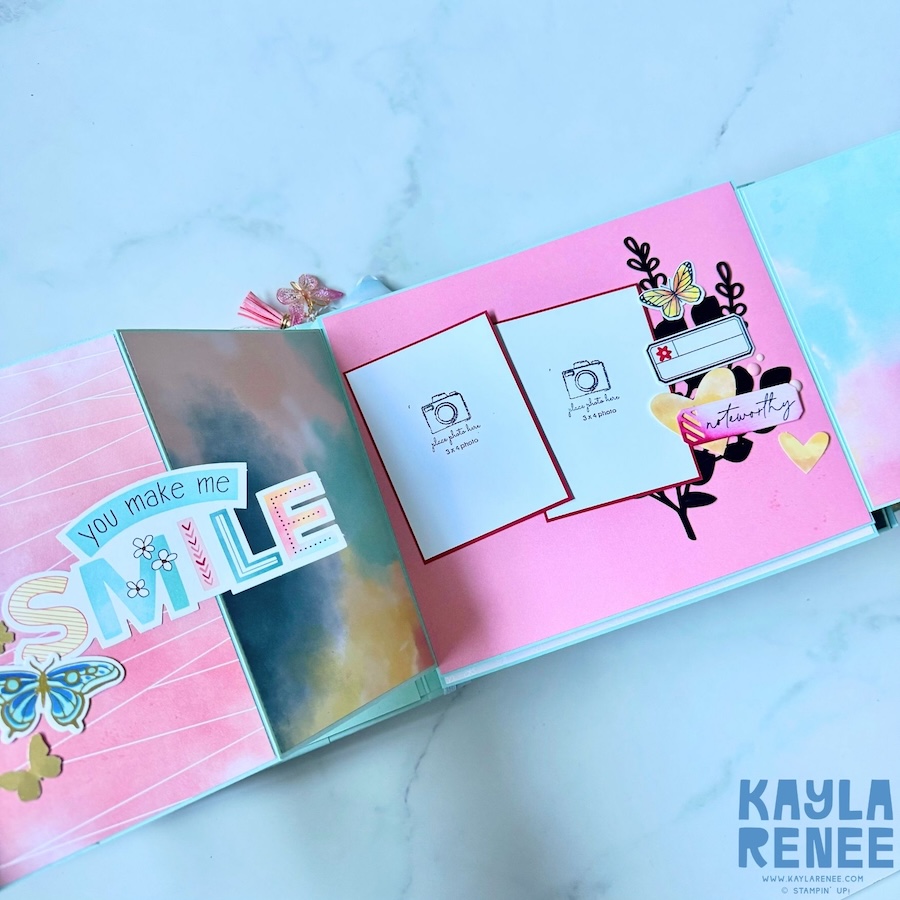 Interactive mini album page showing a large “you make me SMILE” title decorated with colourful butterflies, with a flip panel opened to reveal additional photo mats and embellishments.
