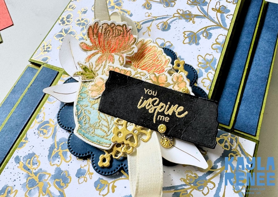 Close-up of a handmade double flip book card featuring the Stampin’ Up! Kintsugi Inspirations Suite, with blue and gold floral patterned paper, layered flowers, a decorative vase, cream ribbon and a black sentiment reading “You inspire me.”